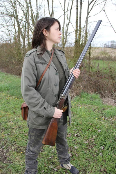 cheerful young woman hunter holding her gun close-up