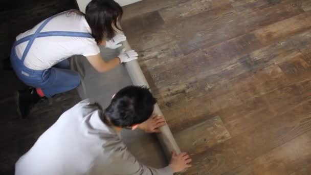 Man Och Kvinna Skydda Golvet Med Plastfolie För Renovering — Stockvideo