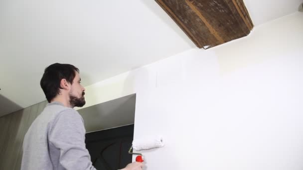 Joven Pintando Pared Con Pintura Blanca — Vídeos de Stock