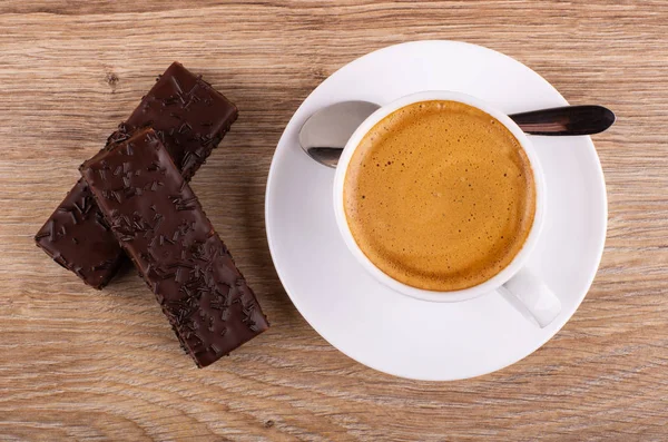 Chocolate wafers, cup of coffee spoon on saucer on table. Top vi