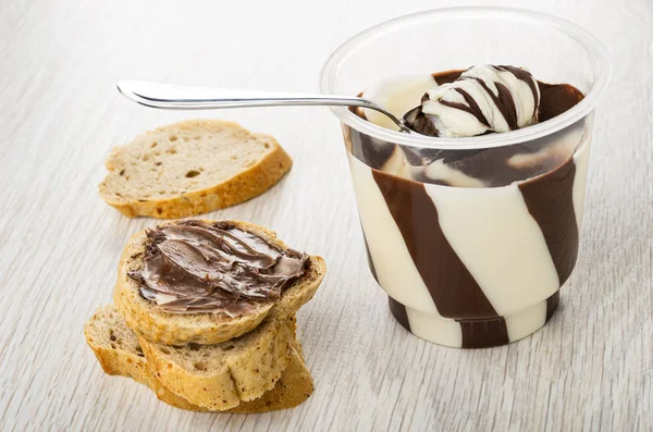 Bread, sandwich with chocolate paste, spoon in jar with paste on