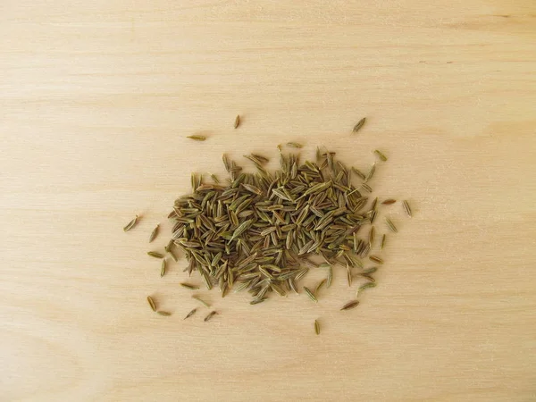木の板にクミンの乾燥種子 — ストック写真
