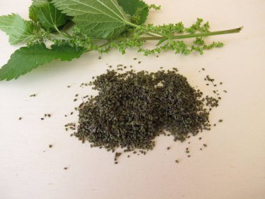 Tahtadaki ısırgan otu ve kurutulmuş ısırgan otu tohumları.