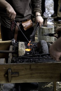 Demirci çelik yığınını ısıtıyor.