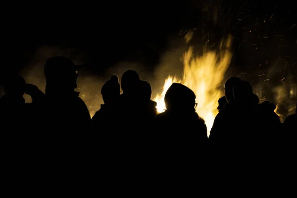 Ludzie tłumią się przy ognisku. — Zdjęcie stockowe