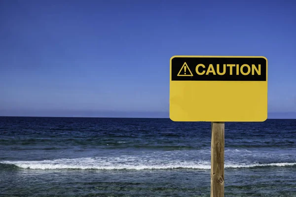 Amarelo sinal de precaução na praia — Fotografia de Stock