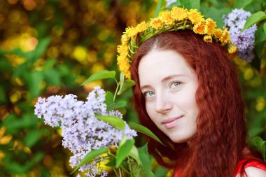 Güzel kızıl saçlı kadın ve bulanık bir arka plan üzerinde çiçek leylak