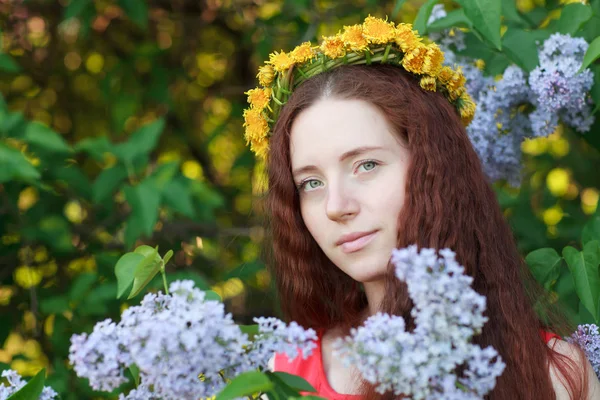 Güzel kızıl saçlı kadın ve bulanık bir arka plan üzerinde çiçek leylak