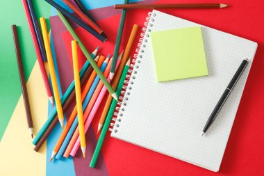 Defter, kalem ve kurşun kalem renkli kağıda yalan