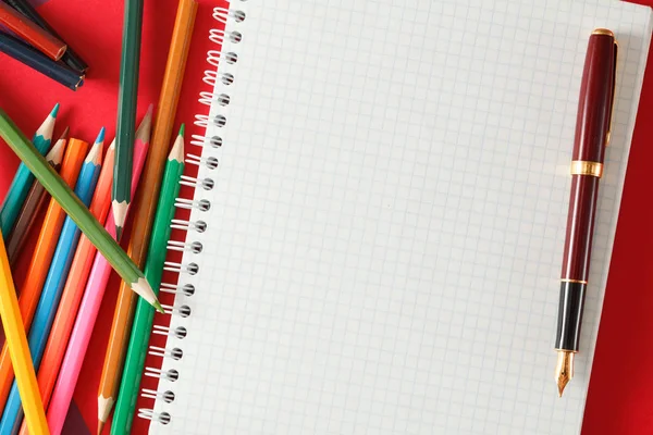 Notebook Czerwone Pióro Ołówki Leżą Papier Kolorowy — Zdjęcie stockowe