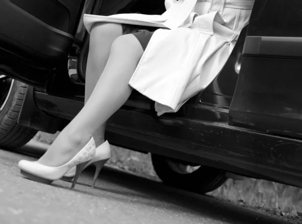 Women's legs out of the car — Stock Photo, Image