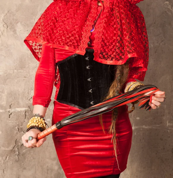 Frau in Rot mit Peitsche in den Händen — Stockfoto