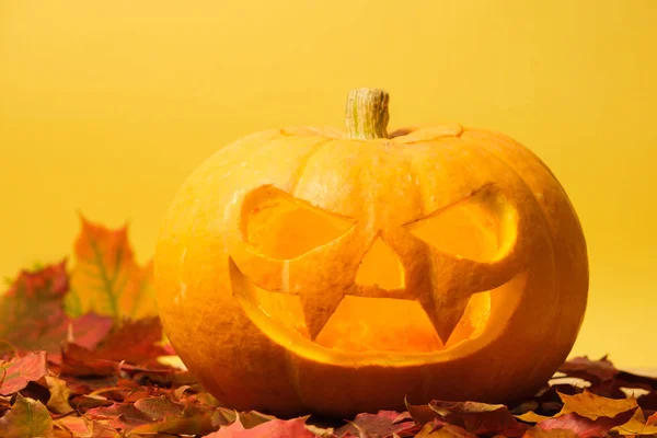 Calabaza de halloween tallada en un amarillo —  Fotos de Stock