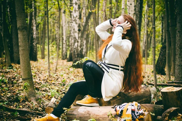 Femme aux cheveux longs et au maquillage lumineux dans le parc d'automne — Photo