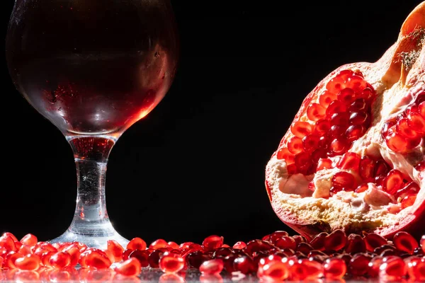 Glass with pomegranate juice and pomegranate seeds on a black — Stock Photo, Image