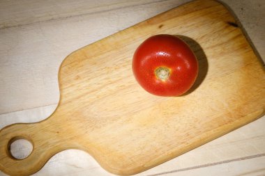 Kesme tahtasında su damlaları olan kırmızı domates.