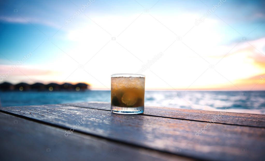 ice cold cocktail in a beach bar on the maldives at sunset