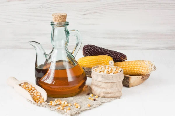 Majsolja Glas Tillbringare Torra Majskorn Och Corncobs Vit Trä Bakgrund — Stockfoto