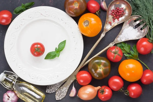 配以白盘子 餐具老式勺子和黑色乡村背景的叉子的新鲜五颜六色的西红柿和蔬菜沙拉 — 图库照片