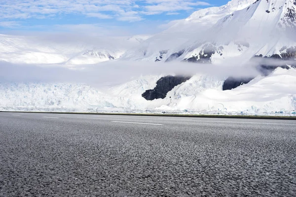 雪山と空のアスファルト道路 — ストック写真