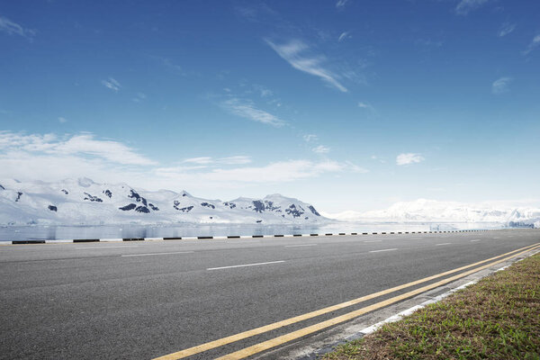 empty asphalt road with snow mountains