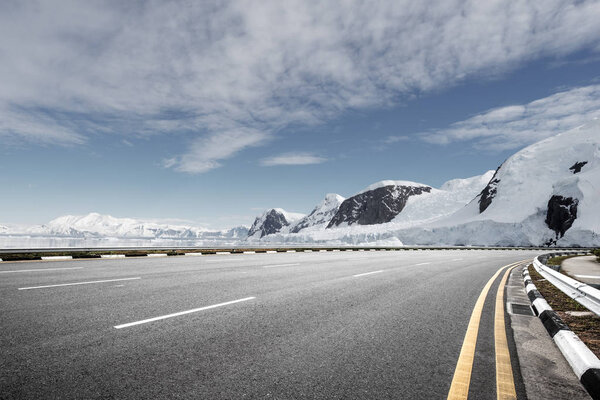 empty asphalt road with snow mountains