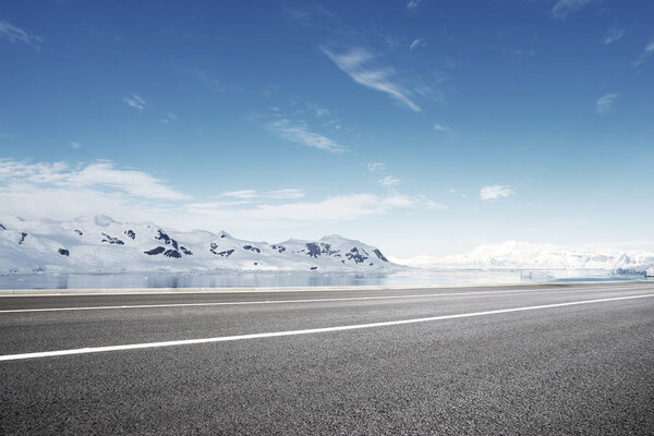 empty asphalt road with snow mountains