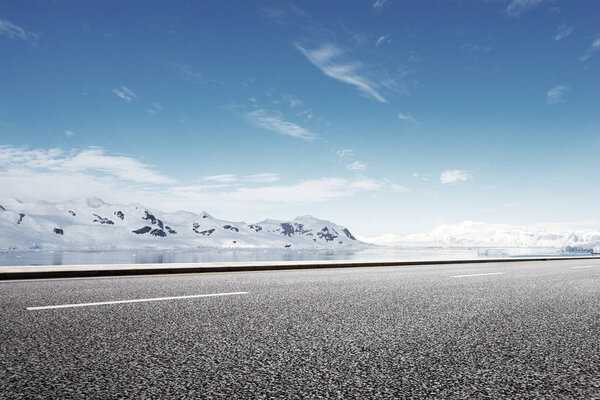 empty asphalt road with snow mountains