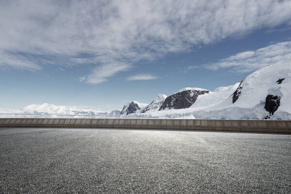 empty asphalt road with snow mountains