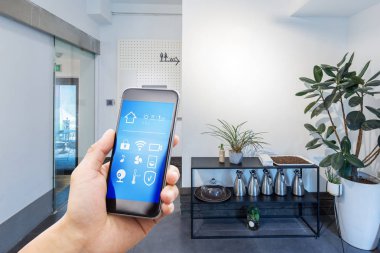 Modern oturma odasında akıllı ev uygulamalı cep telefonu