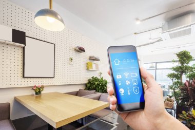 Modern oturma odasında akıllı ev uygulamalı cep telefonu