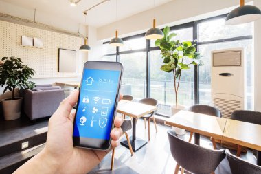 Modern oturma odasında akıllı ev uygulamalı cep telefonu