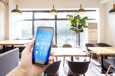 Modern oturma odasında akıllı ev uygulamalı cep telefonu