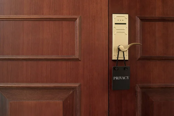 Closed door of hotel room with privacy sign