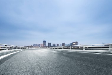 Boş asfalt yol ile modern şehir manzarası