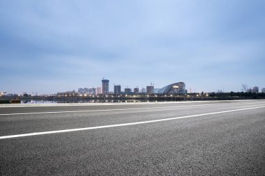 Boş asfalt yol ile modern şehir manzarası