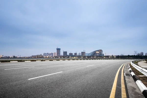 Boş asfalt yol ile modern şehir manzarası