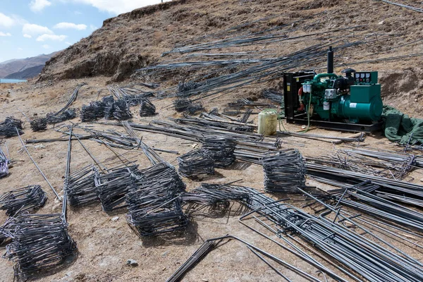 Close up of reinforcement mesh on pile and other construction material and equipment at building site