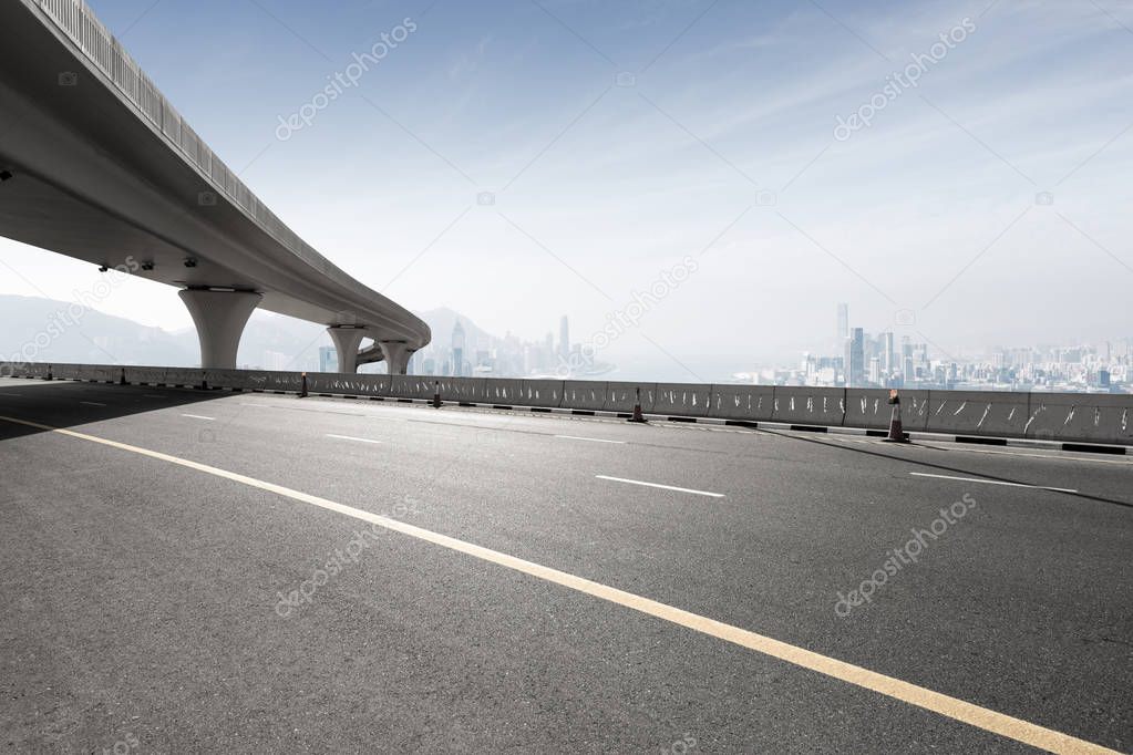 asphalt road with city skyline