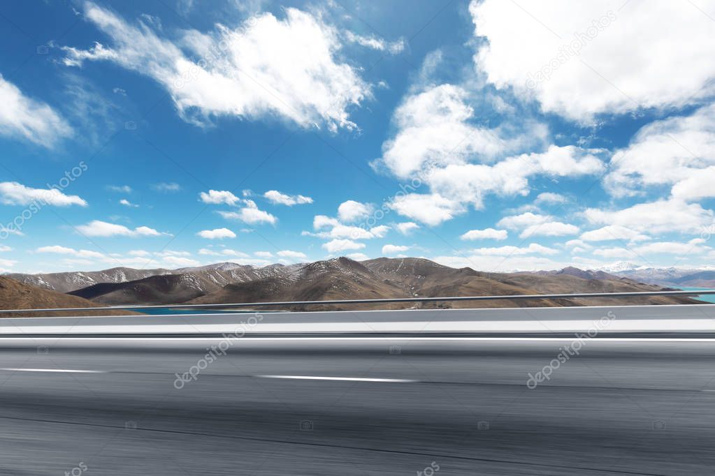 highway through mountains with blue sky 