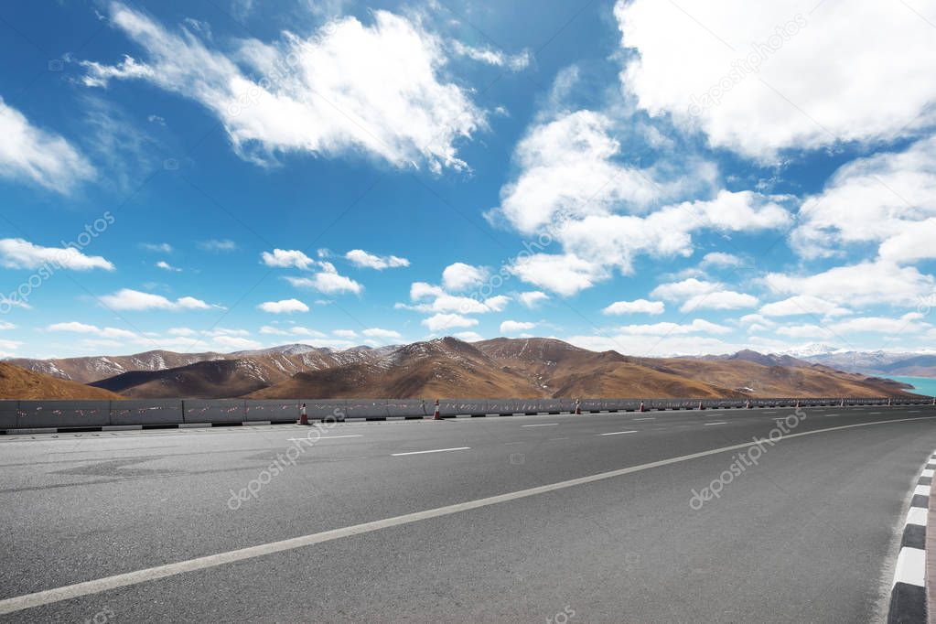 highway through mountains with blue sky 