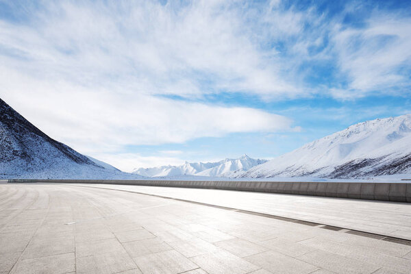 empty brick ground with snow mountain