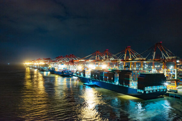 Container ship in export and import business and logistics. Shipping cargo to harbor by crane. Water transport International. Aerial view