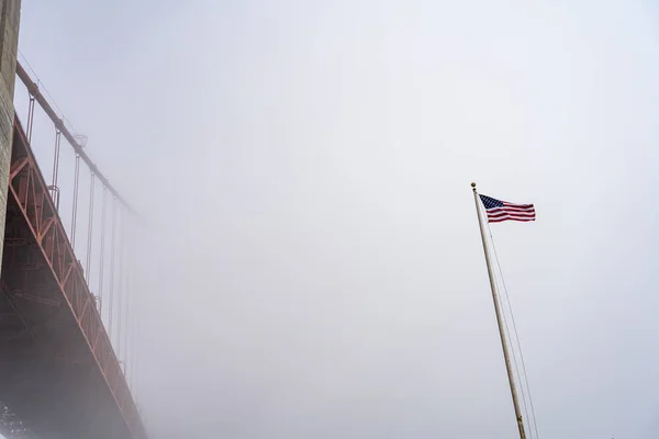 Goldene Torbrücke und US-Flagge im Nebel. — Stockfoto