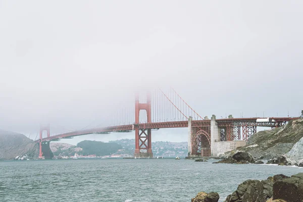 Zicht op Golden Gate Bridge in de mist vanaf het nabijgelegen strand. — Stockfoto