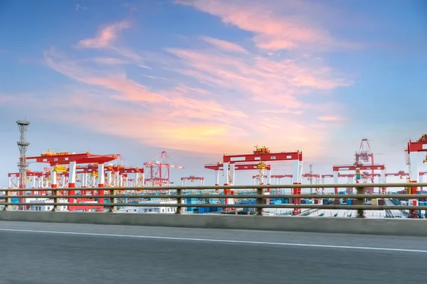 集装箱码头与高速公路对日落辉光天空 — 图库照片