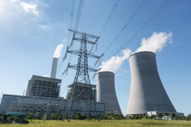 Termik santral ve yüksek gerilim iletim pilon mavi gökyüzü karşı