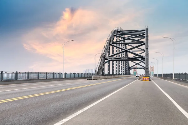 Steel bridge and road with dusk sky — Stock Photo, Image