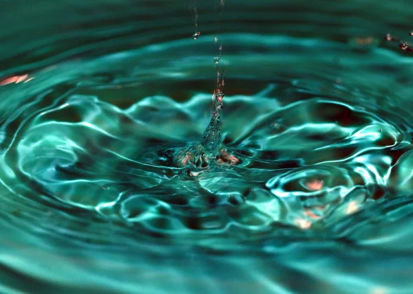 Wunderbare Wasserspritzer Nachdem Ein Tropfen Auf Die Oberfläche Der Flüssigkeit — Stockfoto