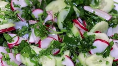 ince kıyılmış taze turp ve salatalık otlar ile bir tabak içinde bir kaşıkla karıştırarak 